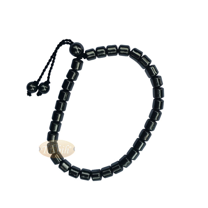 Black cylindrical-bead Islamic tasbih bracelet with adjustable cord.