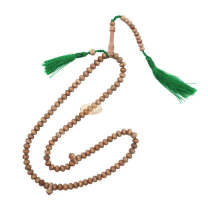 Wooden Islamic misbaha prayer beads with green tassels.
