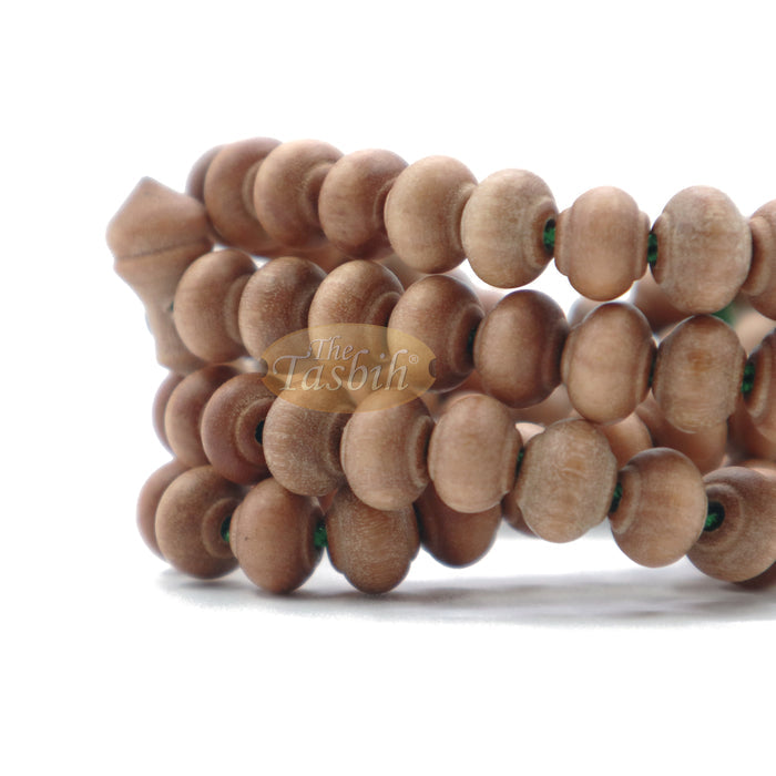 Wooden Islamic misbaha prayer beads with green tassels.
